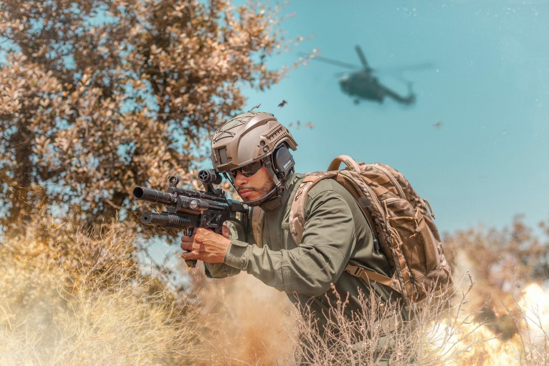Un soldat tient une arme à feu dans le champ.