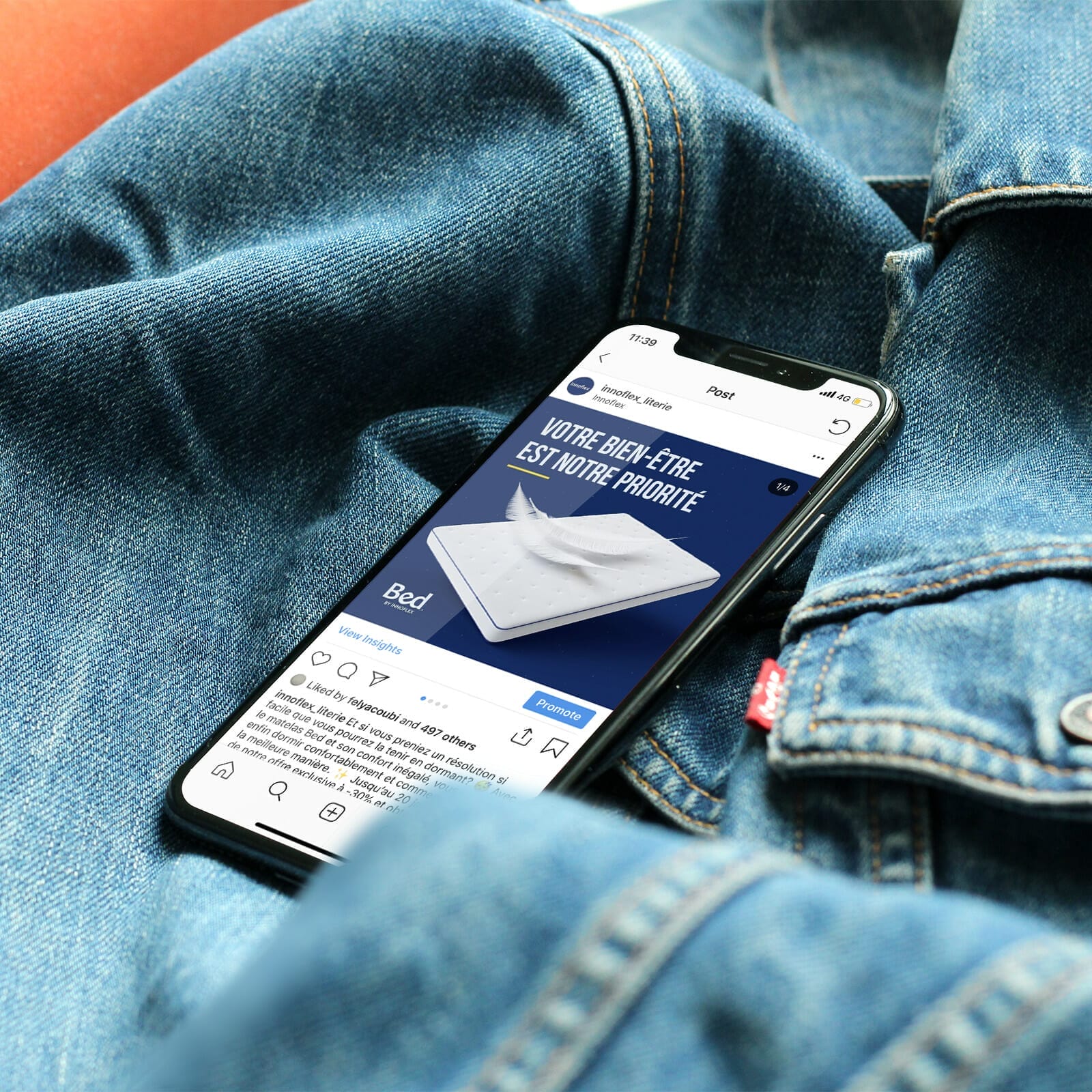 Un iphone est posé sur une veste en jean.