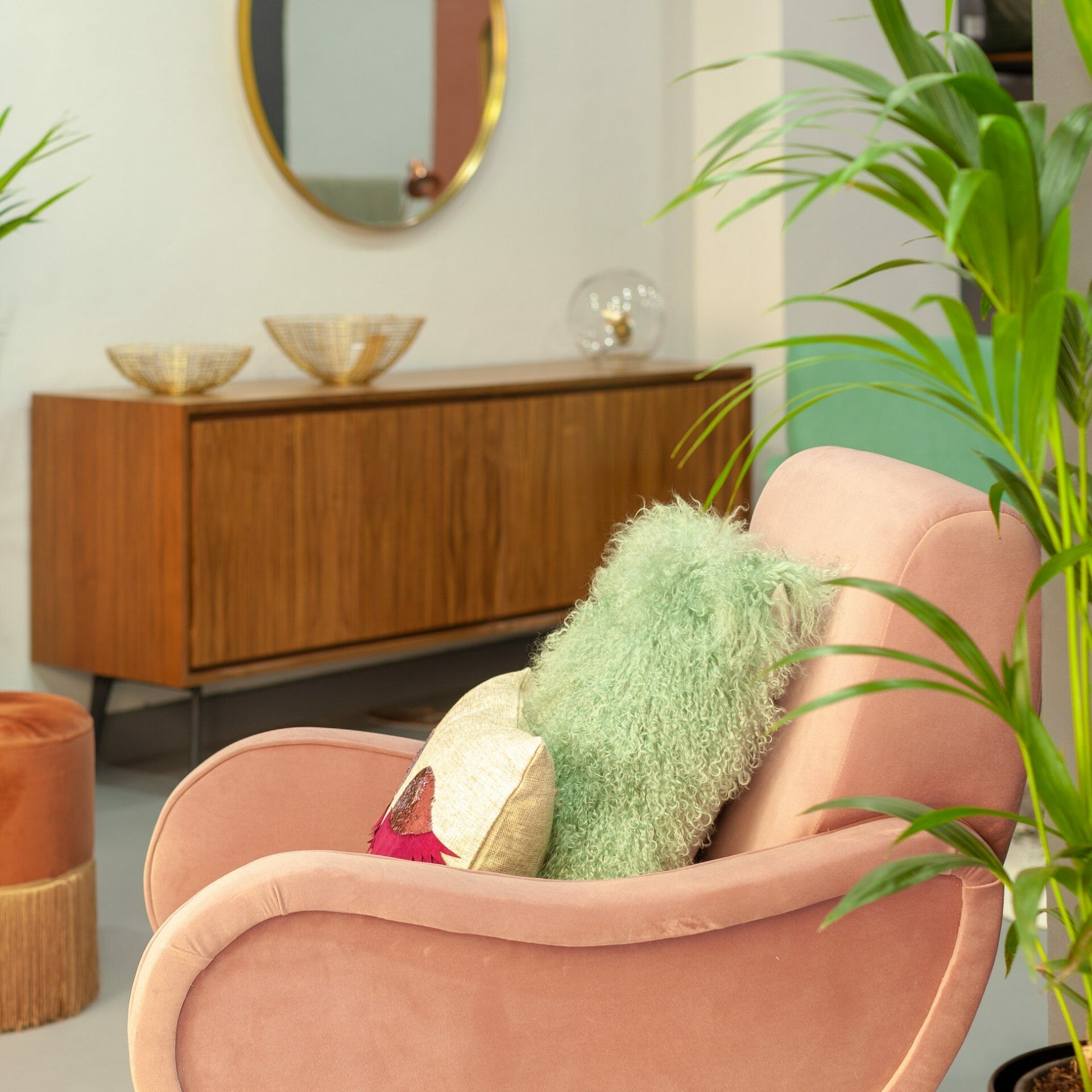 Une chaise rose dans une pièce avec une plante en pot.
